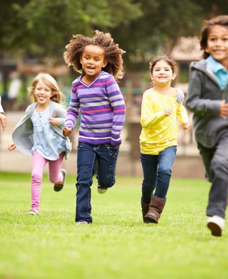 Group Of Young Children Running Towards Camera In Park